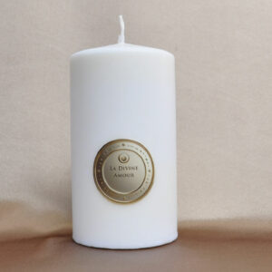 Bougie Divine Amour allumée sur fond doux et chaleureux