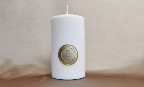 Bougie Divine Amour allumée sur fond doux et chaleureux